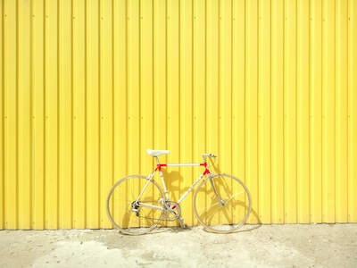 明るい黄色の壁の前に置かれた自転車