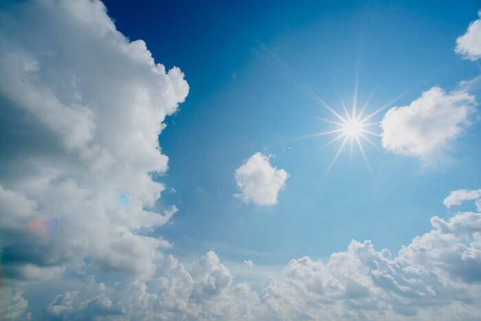 青空と白い雲の間の太陽