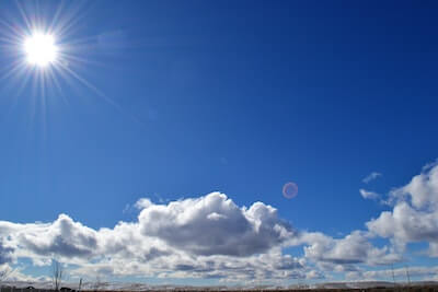 青空に輝く太陽と白い雲