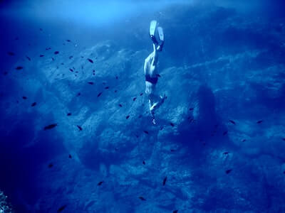 深い海へ潜るダイバー