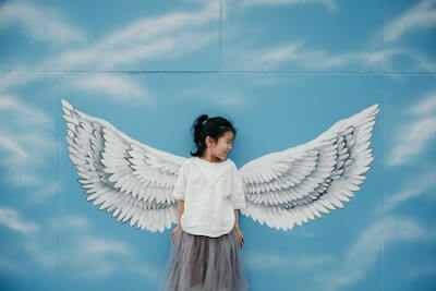 天使の羽の壁画の前で写真を撮る子供