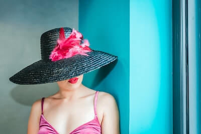 羽飾りのついた帽子を被る女性