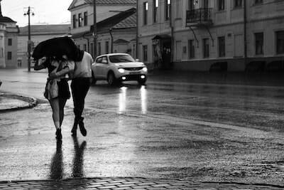 雨の中傘をさして歩く二人