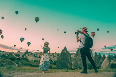 空に浮かぶ熱気球と女性