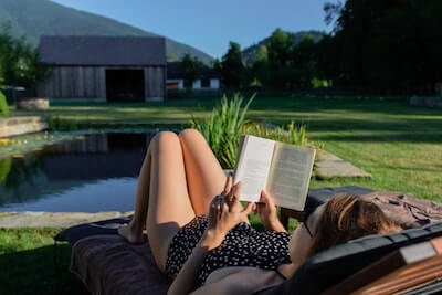庭で本を読む女性